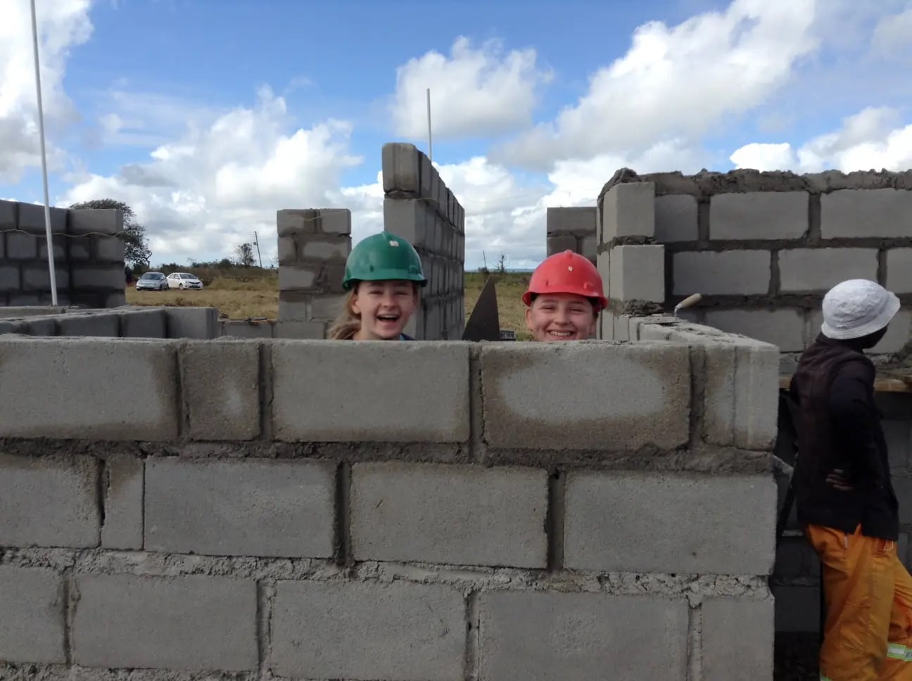 School students building a breeze block wall