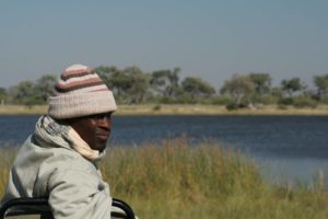 A man in a hat looks out over a lake - 10 items to take on safari