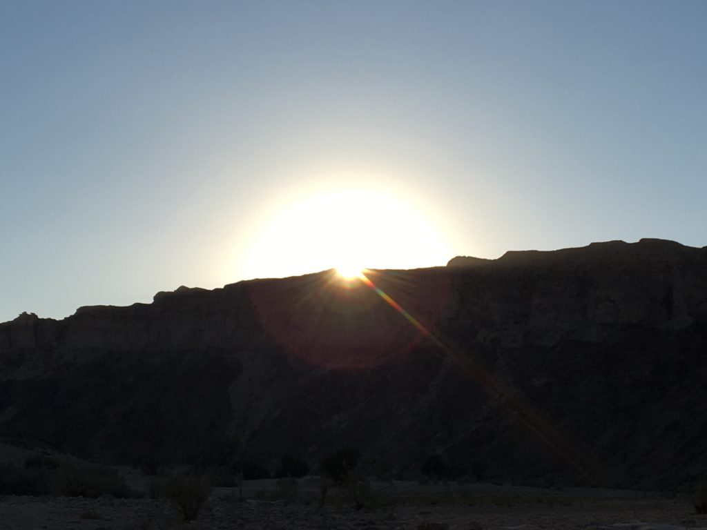 The sun disappears behind the canyon